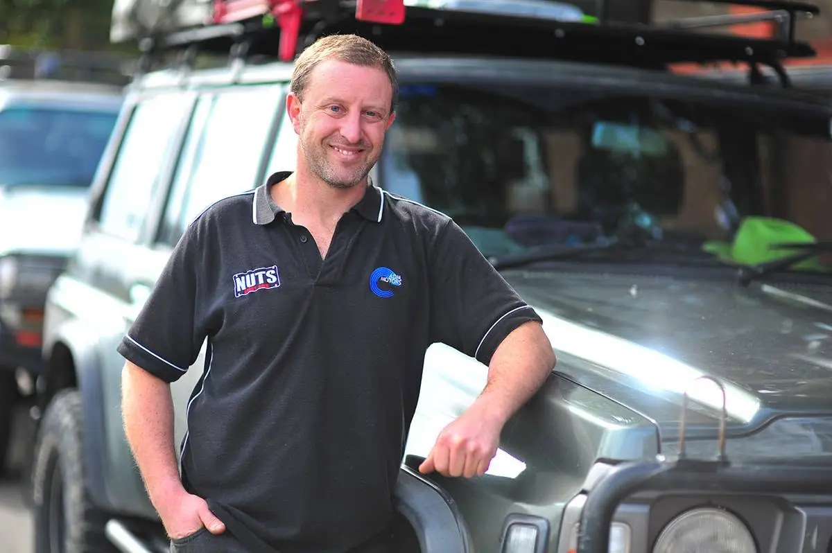 Adam Adler, owner of ADM Motors, standing beside a Nissan Patrol